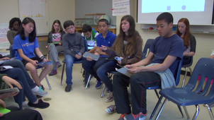 Students sit in a circle for discussion in a classroom